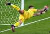 Italy goalkeeper Gianluigi Donnarumma makes a save on Jadon Sancho during the shootout. (Mike Egerton / PA via The Associated Press)