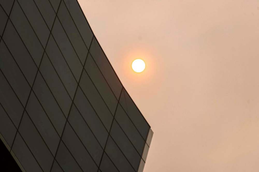 The sun glows red behind a smoke filled sky behind the Canadian Museum for Human Rights Saturday morning. (Mike Sudoma / Winnipeg Free Press)