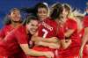 Teammates embrace Canada's Julia Grosso after she scored the winning goal against Sweden in the women's soccer match for the gold medal at the 2020 Summer Olympics on Friday. (Fernando Vergara / The Associated Press)