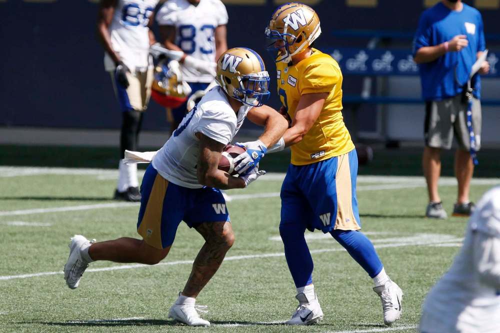 JOHN WOODS / WINNIPEG FREE PRESS
Brady Oliveira (left) takes a handoff from Zach Collaros at Bombers practice Tuesday. Oliveira's performance in the Bombers' season opener earned him honours as one of the CFL's Top Performers of the Week.