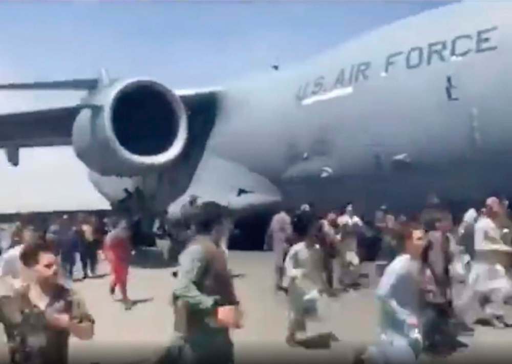 Verified UGC via AP
Hundreds of people run alongside a U.S. Air Force C-17 transport plane as it moves down a runway of the international airport, in Kabul, Afghanistan, Monday. Thousands of Afghans have rushed onto the tarmac of Kabul’s international airport, some so desperate to escape the Taliban capture of their country that they held onto an American military jet as it took off and plunged to death. ()