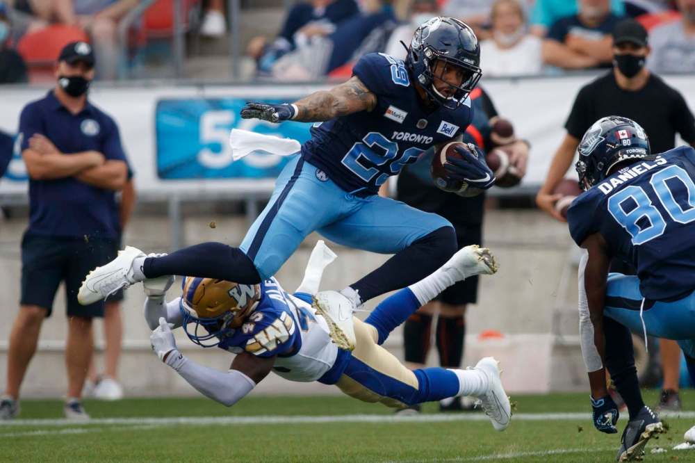Toronto Argonauts D.J. Foster (29) avoids a tackle by Winnipeg Blue Bombers defensive back DeAundre Alford (45) during the first half. (Cole Burston / The Canadian Press)