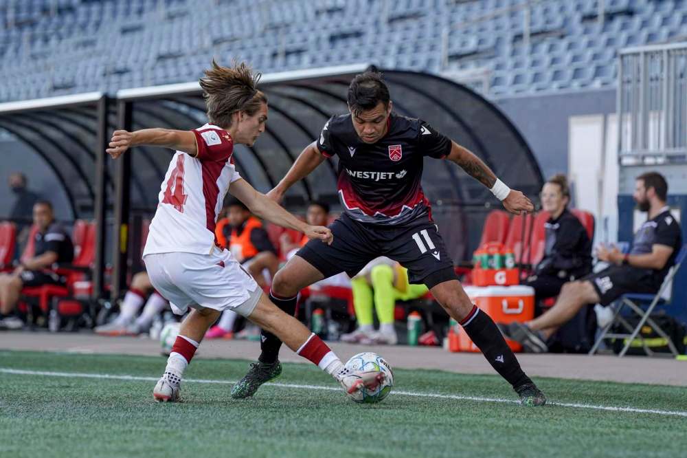 Valour’s Sean Rea tries to put the ball past Cavalry’s Jose Escalante. (Robert Reyes Ong / Valour FC)