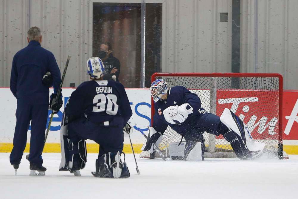 Goalie prospect Arvid Holm sees action in the cage as Moose No. 1 Mikhail Berdin looks on. (John Woods / Winnipeg Free Press)