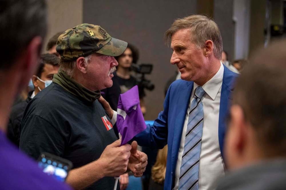 Liam Richards / The Canadian Press
People’s Party of Canada Leader Maxime Bernier, right, speaks to a supporter at PPC headquarters in Saskatoon on election night.