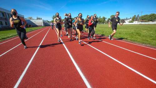 City Couns. Brian Mayes and Devi Sharma run on the rubberized track, along with members of the Garden City Collegiate cross-country team, at the official opening of the school's new track Wednesday. Mike Deal / Winnipeg Free Press