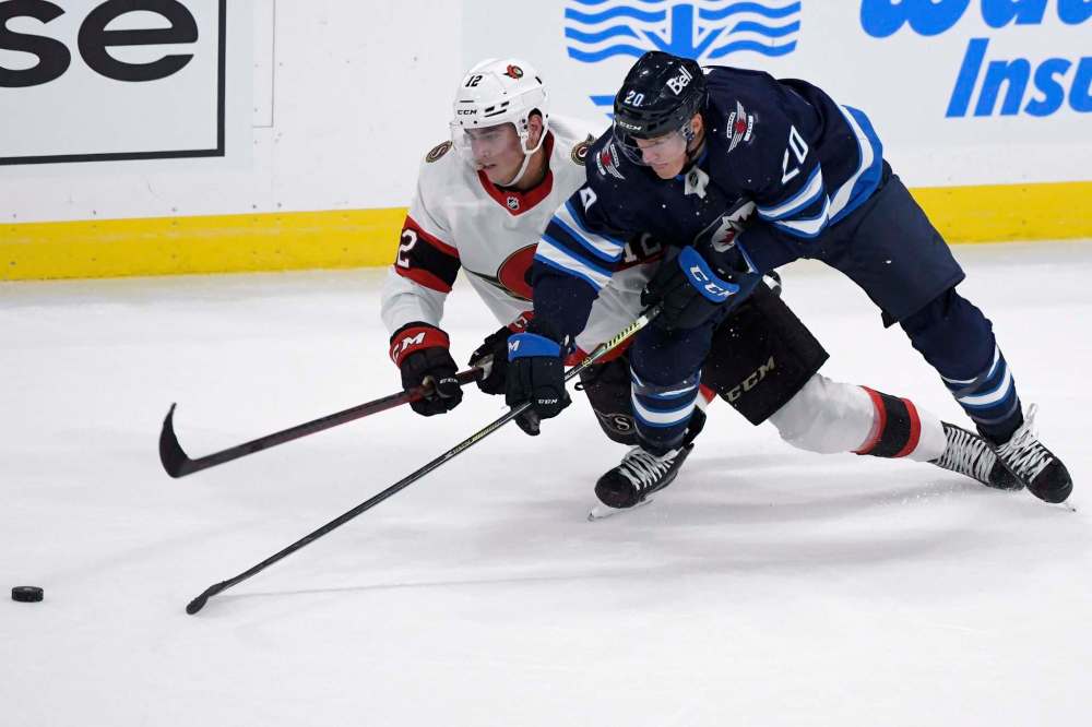Winnipeg Jets’ Riley Nash (right) and Ottawa Senators’ Shane Pinto battles for the puck Sunday night. Nash brings a savvy defending skill to the club. (Fred Greenslade / The Canadian Press)