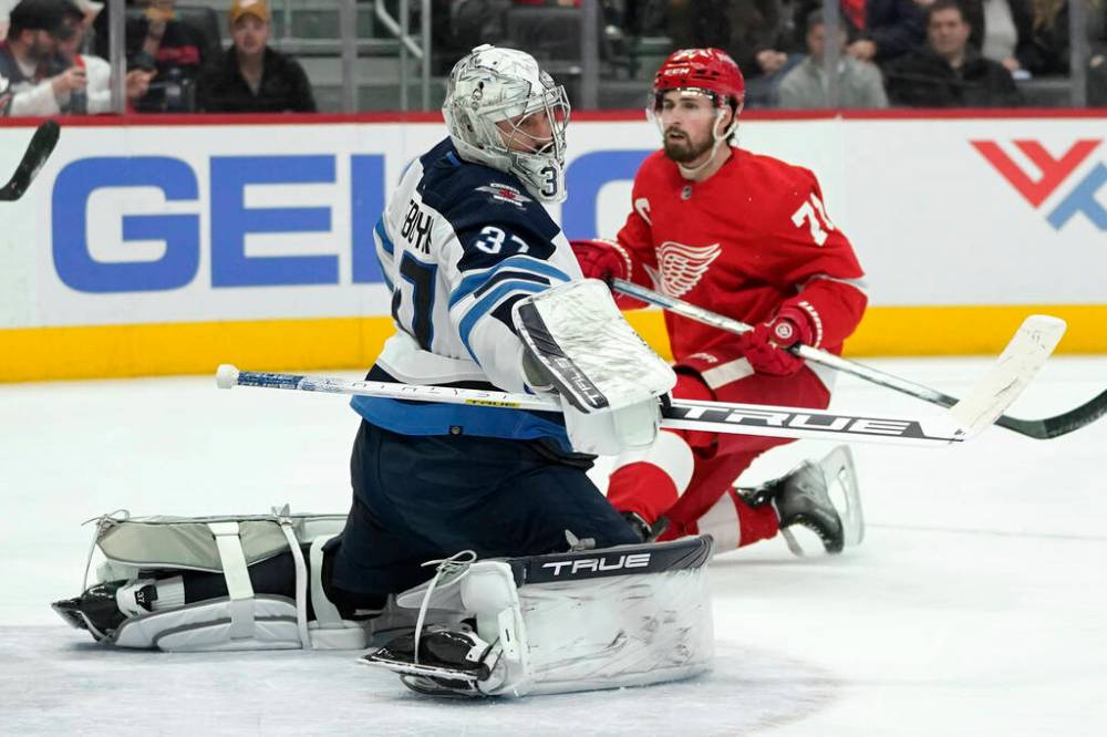 (AP Photo/Paul Sancya)
Winnipeg Jets goaltender Connor Hellebuyck makes one of his 33 saves Thursday against Detroit Red Wings centre Dylan Larkin in the second period.