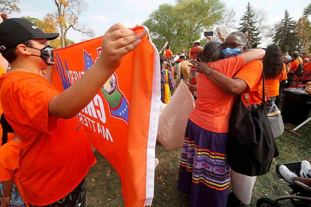 People embrace at a powwow following a Healing Walk through downtown Winnipeg on Thursday. (John Woods / The Canadian Press)