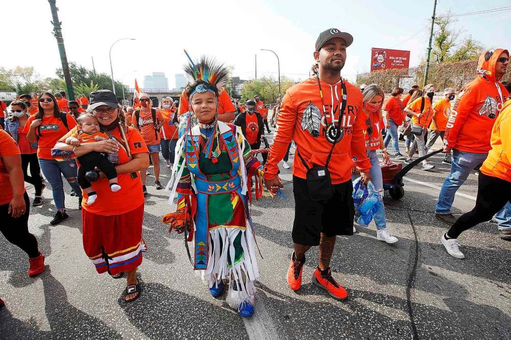 Daniel Hidalgo and his son Daerion joined several thousand gathered for a Healing Walk downtown on Thursday. (John Woods / The Canadian Press)