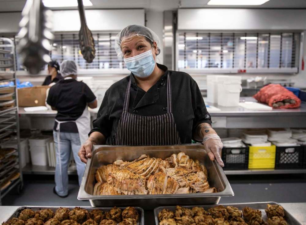 Sonja Lavallee, a staff member at Siloam Mission, holds up a tray of turkey that was served to over 100  community members on Friday. (Jessica Lee / Winnipeg Free Press)