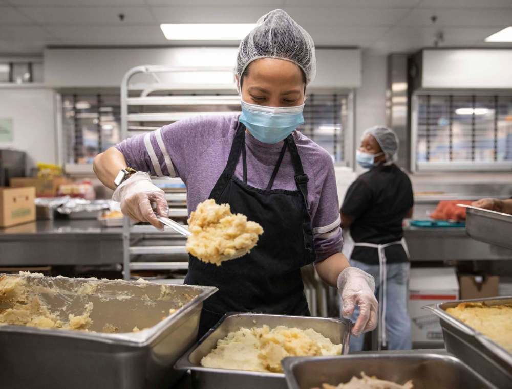 Judith Bulaong scoops mashed potatoes at Siloam Mission on Friday. (Jessica Lee / Winnipeg Free Press)