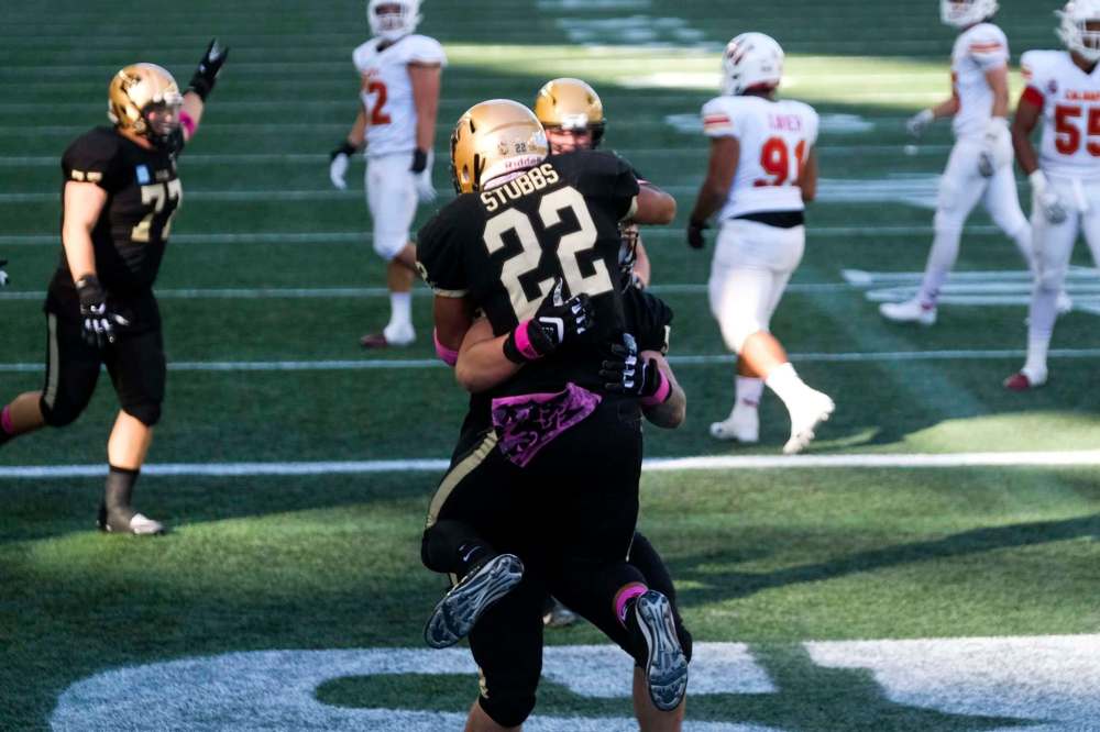 The Bisons celebrate a touchdown to take the lead after Breydon Stubbs (22) carried the ball over the line to take a late game lead against the University of Calgary Dinos at IG Field Saturday. (Daniel Crump / Winnipeg Free Press)
