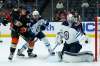 Winnipeg Jets goaltender Connor Hellebuyck, right, blocks a shot by Anaheim Ducks left wing Max Comtois, left, with Winnipeg Jets defenceman Dylan DeMelo, centre, watching during the second period in Anaheim Tuesday. (AP Photo/Alex Gallardo)