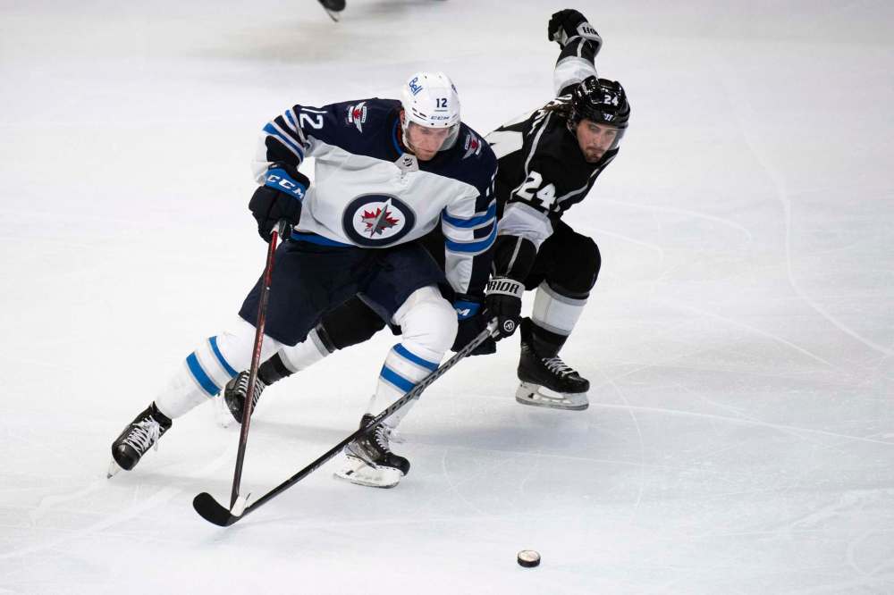 Kyusung Gong / The Associated Press
Winnipeg Jets center Jansen Harkins (12) and Los Angeles Kings left wing Phillip Danault (24) vie for the puck in the third period of an NHL hockey game Thursday, Oct. 28, 2021 in Los Angeles.