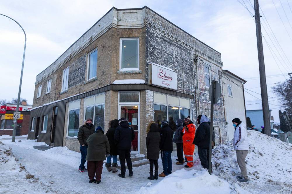 People wait in line for one last order as Blondies Burgers on Main Street flips its last burgers Saturday evening. (Daniel Crump / Winnipeg Free Press)