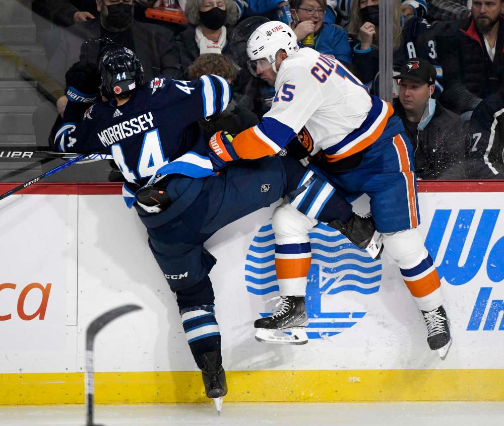 Winnipeg Jets’ Josh Morrissey (44) collides with New York Islanders’ Cal Clutterbuck (15) during the second period. (Fred Greenslade / The Canadian Press)
