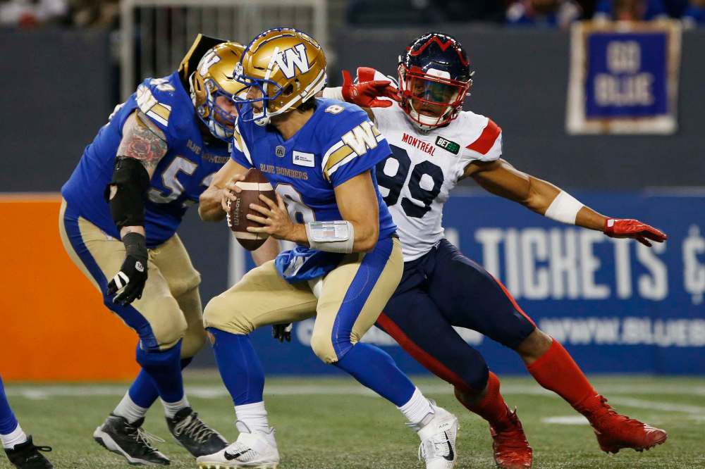 Winnipeg Blue Bombers quarterback Zach Collaros (8) scrambles away from pressure by Montreal Alouettes' Jamal Davis (99) during the second half. (John Woods / The Canadian Press)