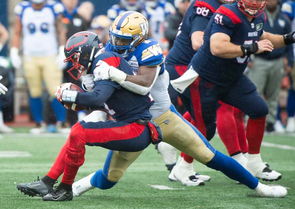 Winnipeg Blue Bombers' Jonathan Kongbo, right, sacks Montreal Alouettes quarterback Trevor Harris during first half. (Graham Hughes / The Canadian Press)