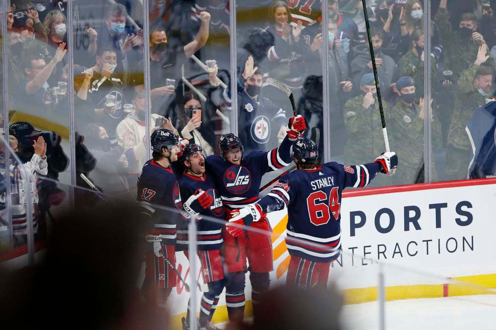 Winnipeg Jets' Adam Lowry (17), Dylan DeMelo (2), Andrew Copp (9) and Logan Stanley (64) celebrate DeMelo’s goal against Los Angeles Kings during third period NHL action in Winnipeg on Saturday, November 13, 2021. (John Woods / The Canadian Press)