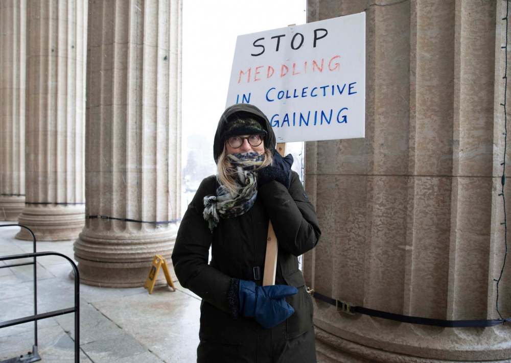 Liv Valmestad joined a handful of members of the University of Manitoba Faculty Association to picket in front of the Manitoba Legislative Building on Wednesday. (Jessica Lee / Winnipeg Free Press)