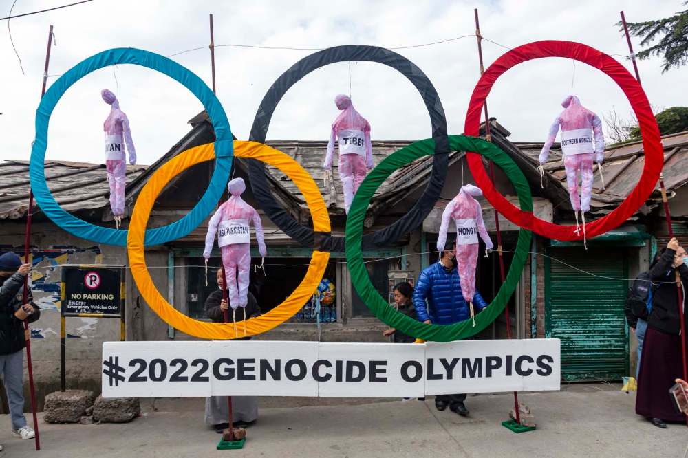 Exiled Tibetans in India use the Olympic Rings as a prop during a street protest earlier this year against the holding of 2022 Winter Olympics in Beijing. (Ashwini Bhatia / The Associated Press files)