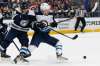 Columbus Blue Jackets' Gustav Nyquist, left, and Winnipeg Jets' Nikolaj Ehlers fight for a loose puck during the first period Wednesday in Columbus, Ohio. (AP Photo/Jay LaPrete)