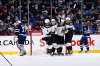 Arizona Coyotes' Antoine Roussel celebrates his goal on Winnipeg Jets goaltender Connor Hellebuyck with teammates during the second period in Winnipeg, Monday. THE CANADIAN PRESS/Fred Greenslade