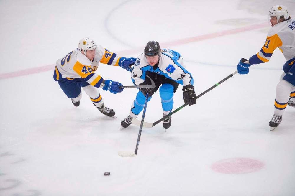 Mike Sudoma / Winnipeg Free Press
Winnipeg Ice forward Mikey Milne carries the puck past a pair of Saskatoon Blades Friday night at Wayne Fleming Arena.