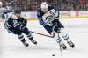 Winnipeg Jets' Blake Wheeler, right, carries the puck up ice as Columbus Blue Jackets' Yegor Chinakhov defends during the first period of an NHL hockey game Wednesday, Nov. 24, 2021, in Columbus, Ohio. (AP Photo/Jay LaPrete)