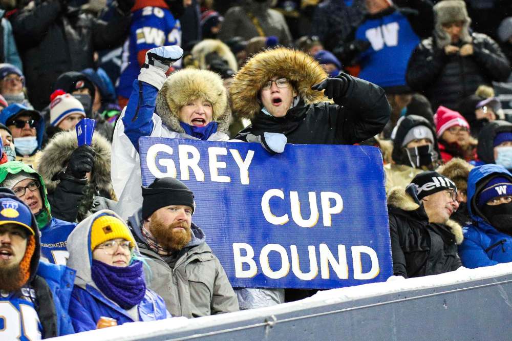Fans hold a sign predicting a place in the Grey Cup final next Sunday/ (Daniel Crump / Winnipeg Free Press)