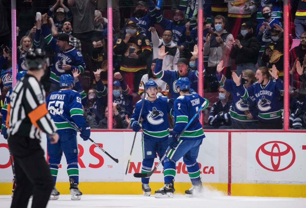 Vancouver Canucks' Nils Hoglander, centre, celebrates his goal against the Winnipeg Jets with Luke Schenn, right, and Bo Horvat during the first period in Vancouver, on Friday. THE CANADIAN PRESS/Darryl Dyck