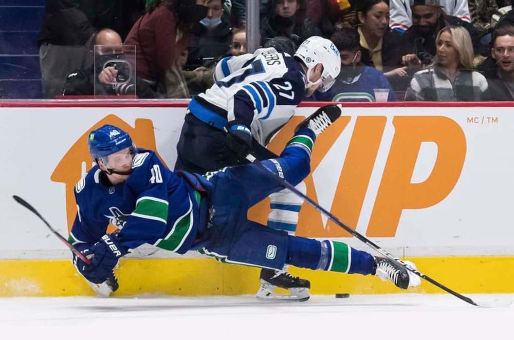 Winnipeg Jets' Nikolaj Ehlers trips Vancouver Canucks' Elias Pettersson during overtime. THE CANADIAN PRESS/Darryl Dyck