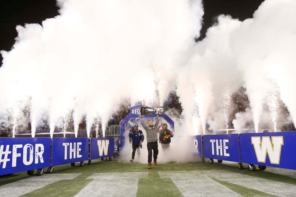 Nick Hallett leads the team out as the Winnipeg Blue Bombers and fans celebrate after their Grey Cup win on Sunday over the Hamilton Tiger-Cats during a Grey Cup celebration at IG Field in Winnipeg on Wednesday. THE CANADIAN PRESS/John Woods