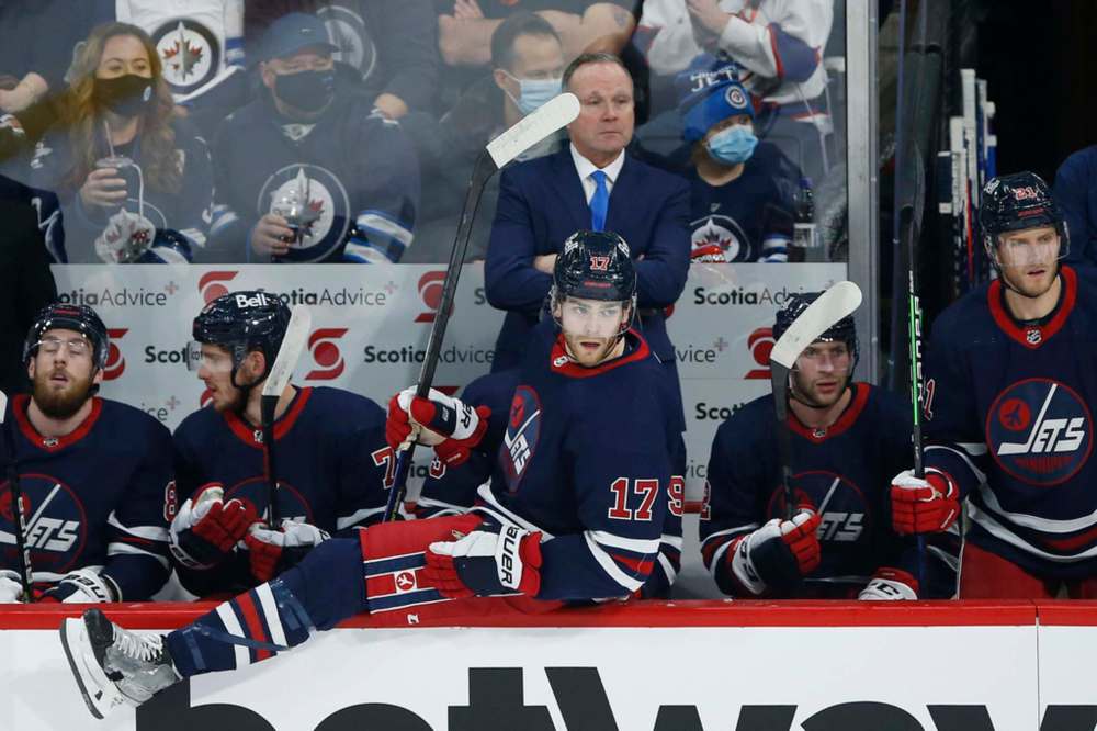 Winnipeg Jets' Adam Lowry goes over the boards as his father, the new interim head coach, Dave Lowry, looks on against the Washington Capitals during the first period in Winnipeg on Friday. THE CANADIAN PRESS/John Woods