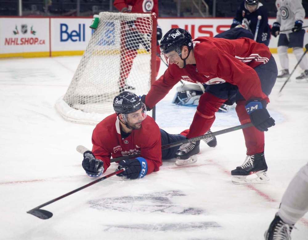 JESSICA LEE / WINNIPEG FREE PRESS
Neal Pionk (right) helps Dylan DeMelo after a fall during Jets practice on Tuesday.