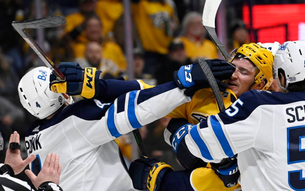 Winnipeg Jets defenceman Neal Pionk, left, scuffles with Nashville Predators left wing Tanner Jeannot during the second period. (AP Photo/Mark Zaleski)