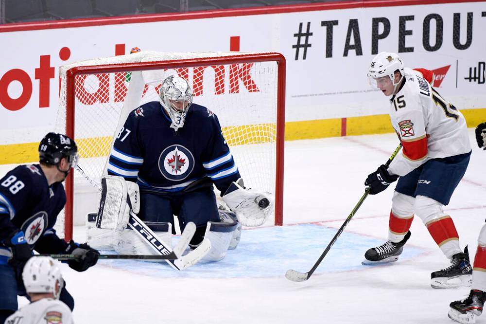 Winnipeg Jets goaltender Connor Hellebuyck makes a save on Florida Panthers’ Anton Lundell during the second period of NHL action in Winnipeg on Tuesday. THE CANADIAN PRESS/Fred Greenslade
