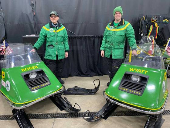 Roger Kram (left) and son Wyatt with their identical 1973 John Deere 400 snowmobiles. (Supplied)