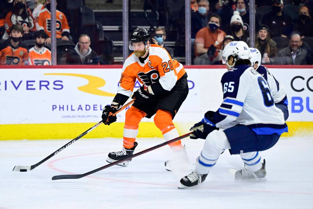 Philadelphia Flyers’ Claude Giroux, left, skates the puck past Winnipeg Jets’ Johnathan Kovacevic (65) and Josh Morrissey, rear, during the second period. (AP Photo/Derik Hamilton)