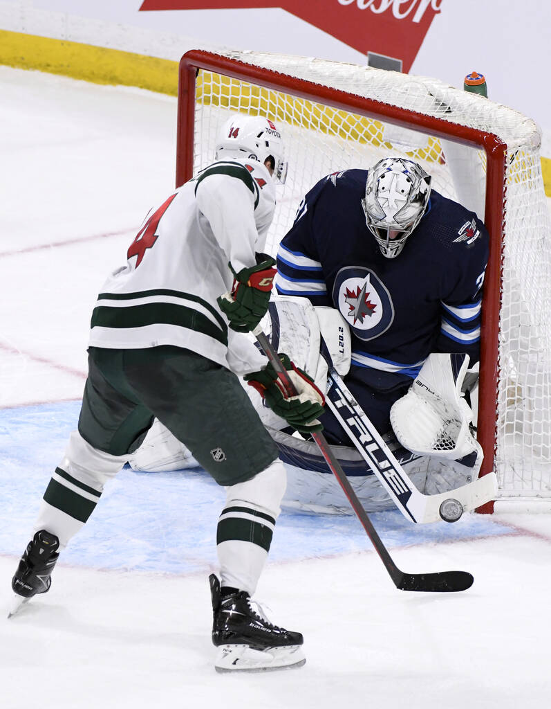 Winnipeg Jets’ goaltender Connor Hellebuyck makes a save on Minnesota Wild’s Joel Eriksson Ek during the third period. THE CANADIAN PRESS/Fred Greenslade