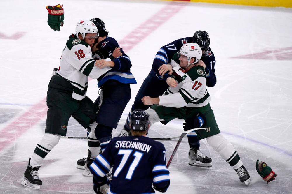 Minnesota Wild’s Jordan Greenway and Marcus Foligno tangle with Winnipeg Jets’ Brenden Dillon and Adam Lowry during the first period. THE CANADIAN PRESS/Fred Greenslade