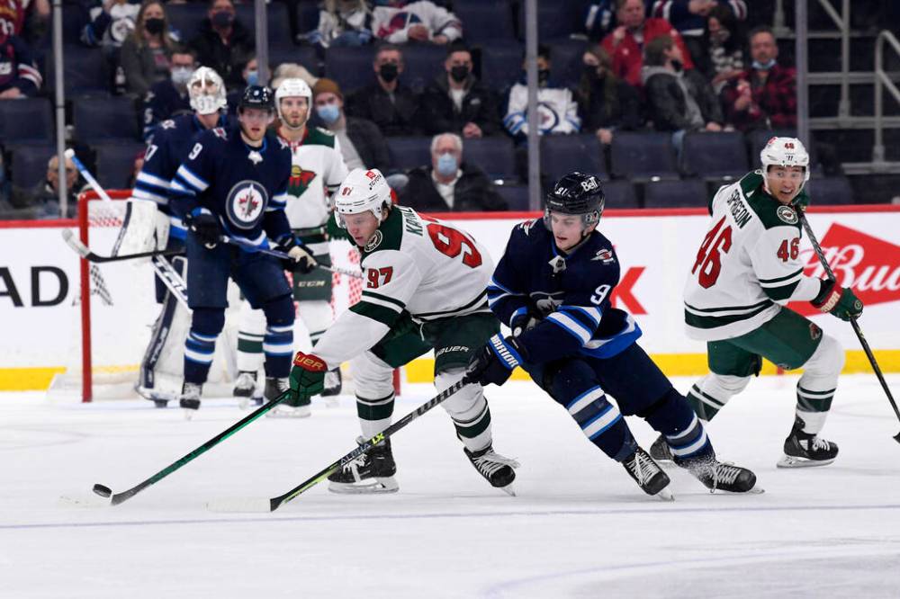 Minnesota Wild’s Kirill Kaprizov passes puck past Winnipeg Jets’ Cole Perfetti during the second period. THE CANADIAN PRESS/Fred Greenslade