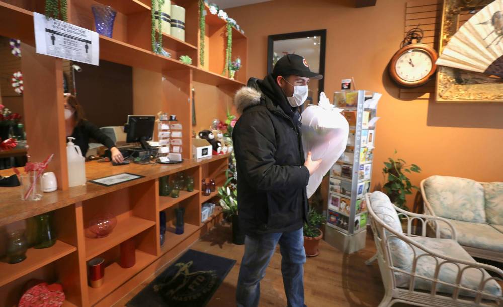 RUTH BONNEVILLE / WINNIPEG FREE PRESS 
Roy’s Florist customer, Brendan Markus, leaves the store with a large bouquet on Valentine’s Day.