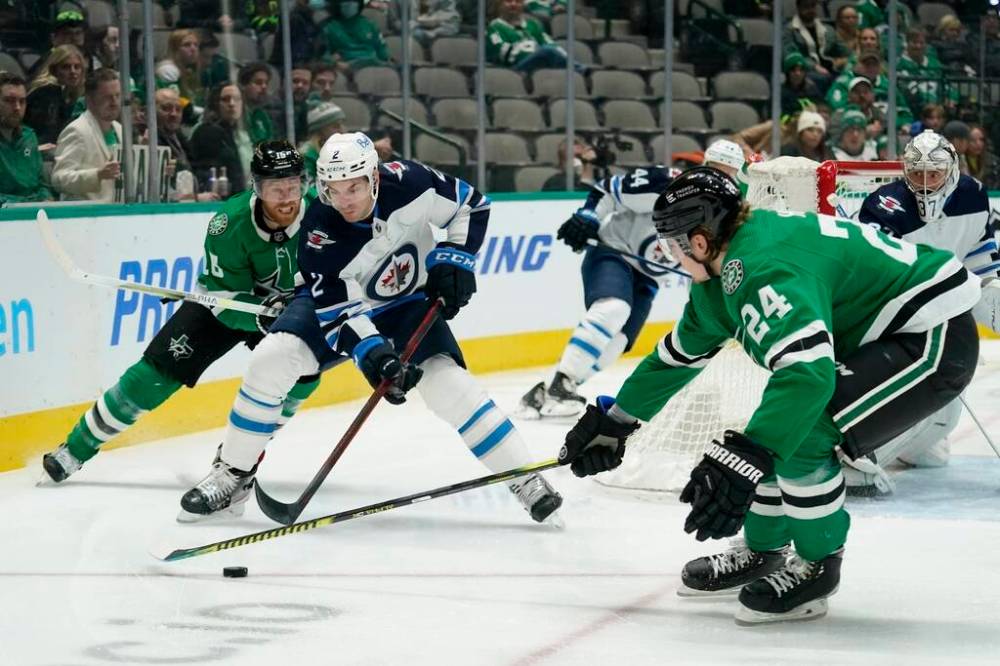 Winnipeg Jets defenceman Dylan DeMelo attempts to maintain control of the puck under pressure from Dallas Stars centre Joe Pavelski and Roope Hintz in the first period in Dallas, Wednesday. (AP Photo/Tony Gutierrez)