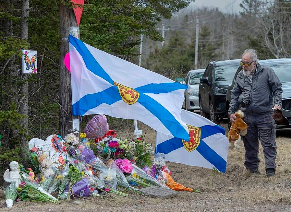 A man pays his respects at a roadside memorial in Portapique, N.S., on April 23, 2020, after a mass shooting days earlier that left 22 people dead. (Andrew Vaughan / The Canadian Press files)