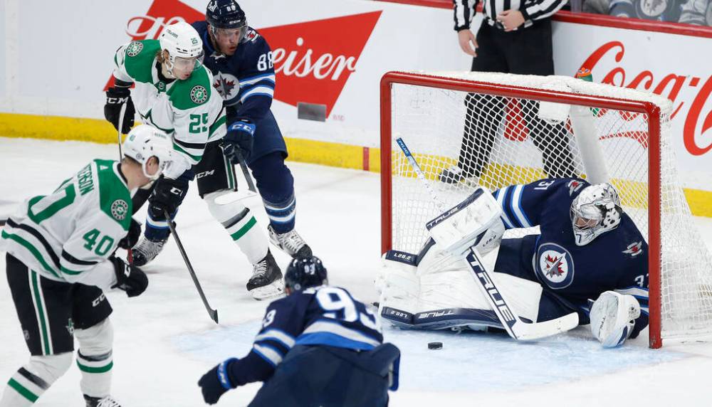 Winnipeg Jets goaltender Connor Hellebuyck saves a shot from Dallas Stars’ Jacob Peterson during the first period in Winnipeg on Friday. THE CANADIAN PRESS/John Woods