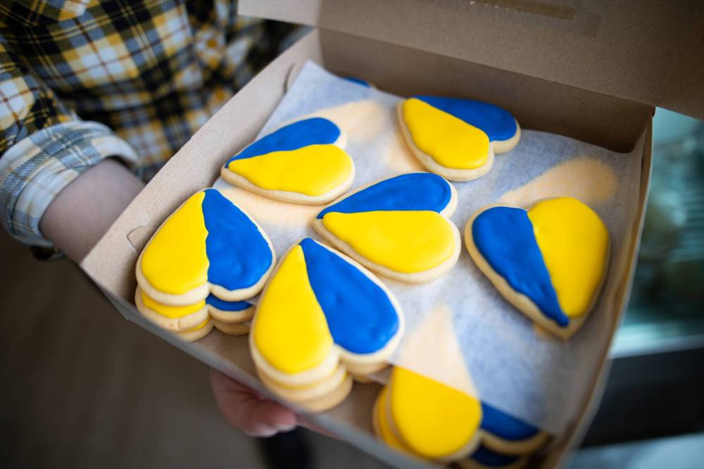 Goodies Bake Shop is selling heart-shaped sugar cookies decorated with gold and blue icing to raise money for Ukraine, with customers lining up to buy them. (Daniel Crump / Winnipeg Free Press)