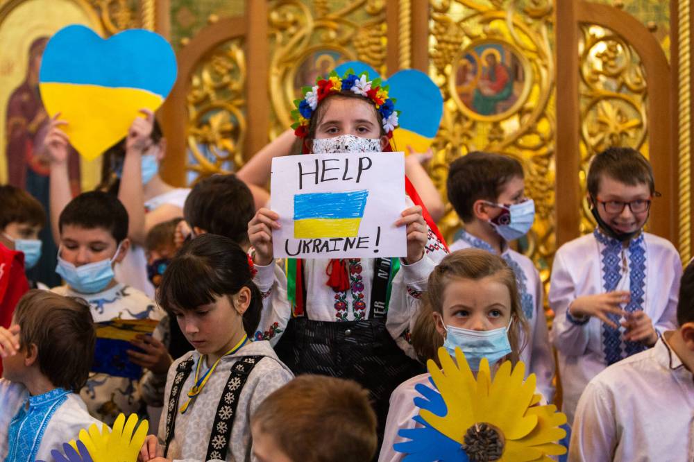 Kids say prayers for Ukraine at the Ukrainian Catholic Metropolitan Cathedral of Sts. Volodymyr and Olga on McGregor Street on Saturday. (Daniel Crump / Winnipeg Free Press)