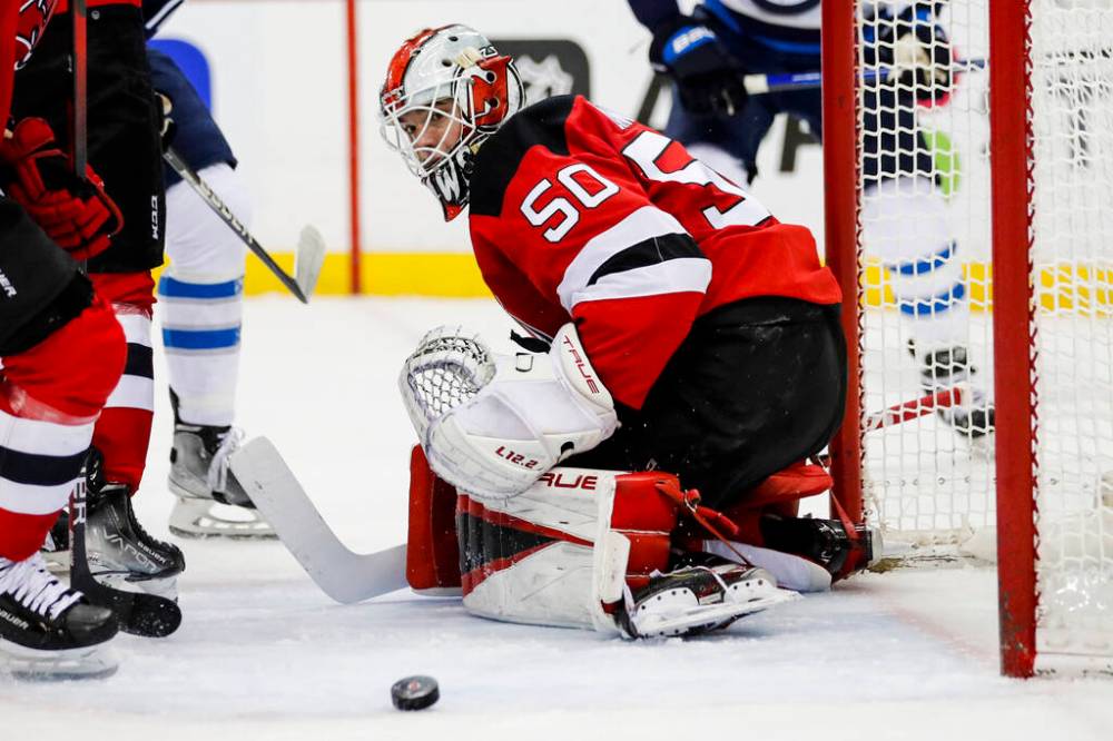 New Jersey Devils goaltender Nico Daws keeps an eye on the puck after stoping a shot by the Winnipeg Jets during the second period. (AP Photo/Eduardo Munoz Alvarez)